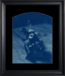 Framed blue-toned still life photograph.