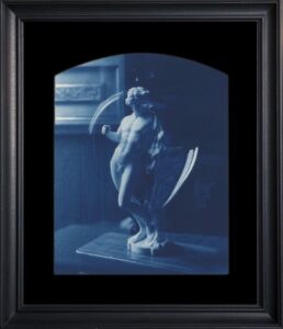 Framed statue of a winged figure.