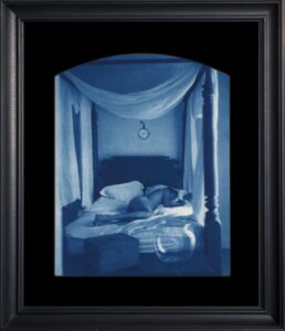 Framed photograph of a person in bed.