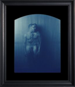 A man holding an object, blue tint.