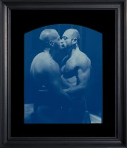 Two men sharing a kiss in blue.