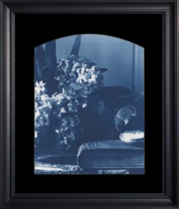 Framed monochrome floral and portrait arrangement.