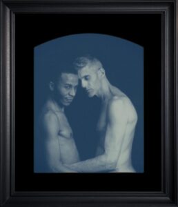 Two people embracing in framed monochrome photo.