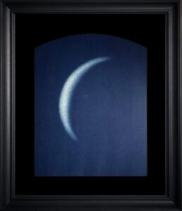 Framed artwork of a crescent shape.