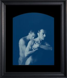 Two men embracing in monochrome photograph.