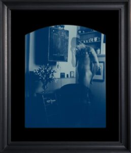 Framed blue-tinted photograph of a person.